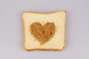 Homemade peanut butter and heart shaped sandwich on white background. The concept of love for food. Favorite breakfast.