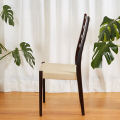 Midcentury modern dining room chair. Vintage rosewood chair with fabric seat. Product photograph in...