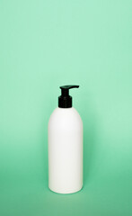 White blank unbranded cosmetic plastic bottle with black dispenser pump for shampoo, gel, lotion, cream, bath foam.