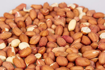A lot of unpeeled peanuts isolated on a white background. Clipping path. Full depth of field. background image.