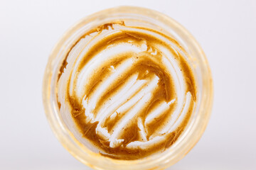 Peanut butter in an open jar. Empty peanut butter container. The last spoonful of delicious pasta snacks.