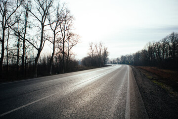 Fototapeta premium New asphalt road with markings and road signs in the sun's rays