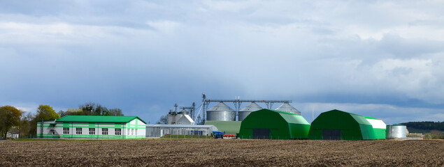 Large green hangars near the field.