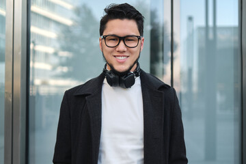 An Asian guy businessman in a headphones mid shot, outdoor