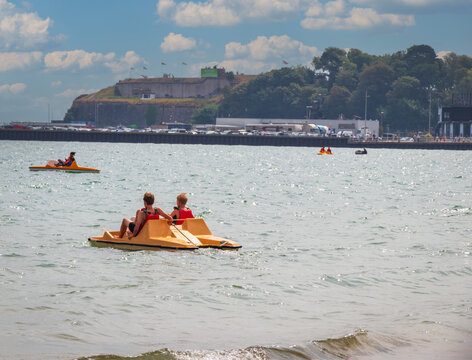 Kids using peddle boat at Weymouth beachfront England