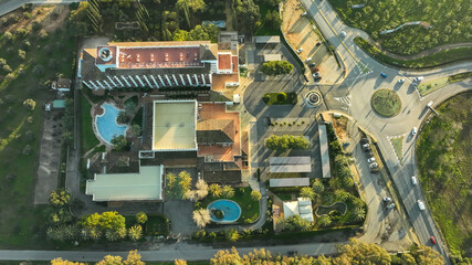Vista aerea de un hotel con encanto y piscina en mitad de carretera y ciudad. DJI MAVIC 3...
