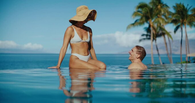 Attractive couple relaxing in the pool at tropical luxury resort spa, vacation honeymoon travel