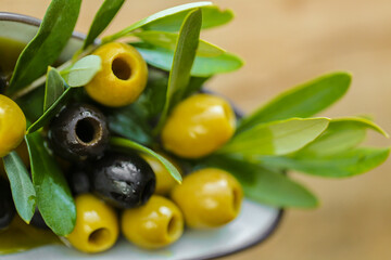 Olives and olive oil.mediterranean cuisine ingredient. Black and green olives and a green olive branch close-up in olive oil . Fresh bio organic olives and black olives.
