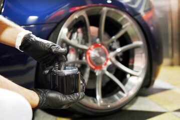 Professional detailer takes care of and cleans a car down to the smallest detail using new generation nanotechnological products