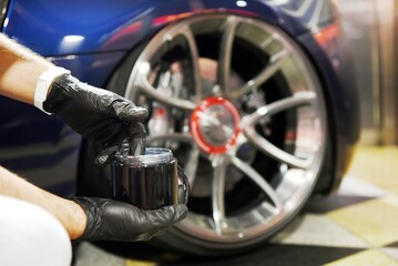 Fototapeta premium Professional detailer takes care of and cleans a car down to the smallest detail using new generation nanotechnological products