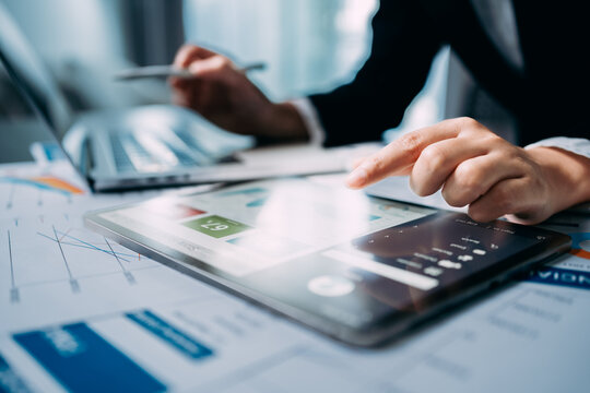 Close up of view Businesswomen using digital tablet and laptop computer to analyze business report graphs and finance charts at the workplace, Business strategy, financial and investment concepts.