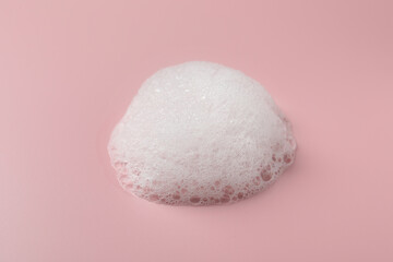 Drop of fluffy soap foam on pink background