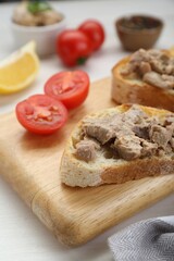 Fototapeta na wymiar Tasty sandwiches with cod liver on white wooden table