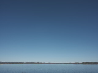 a clear blue sky over a still lake