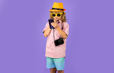 Cute child takes picture with camera and phone. Traveller kid boy chatting on phone. Vacation travel lifestyle.
