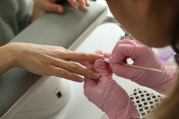 Professional manicurist working with client in beauty salon, closeup