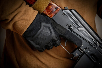 A warrior with an assault rifle AK-74 in tactical gloves.