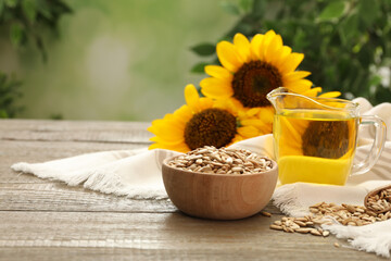 Sunflower oil and seeds on wooden table against blurred background, space for text