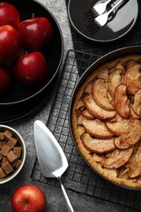 Delicious apple pie and ingredients on grey table, flat lay