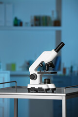 Modern medical microscope on metal table in laboratory