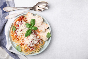Delicious pasta with tomato sauce, chicken and parmesan cheese on white table, flat lay. Space for text