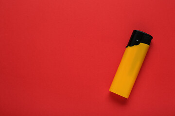 Stylish small pocket lighter on red background, top view. Space for text