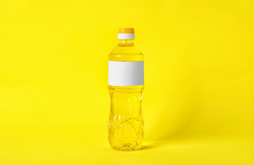 Bottle of cooking oil on yellow background