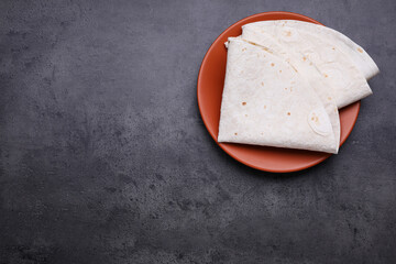 Delicious folded Armenian lavash on dark table, top view. Space for text