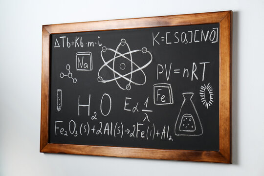 Blackboard with different chemical formulas written with chalk on white wall