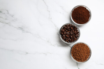 Bowls of beans, instant and ground coffee on white marble table, flat lay. Space for text