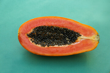 Half of fresh ripe papaya fruit on light blue background