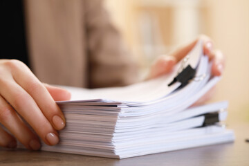 Woman working with documents at table in office, closeup