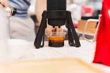 Barista making espresso coffee using Aeropress in cafe.
