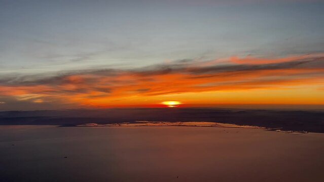 Stunning red sunset over the Mediterranean sea fliying boud Valencia, with the Valencia&rsquo;s Lagoon and the city in front. Pilot point of view at 7000m high. Untouched colors.