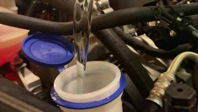 Static Shot Of Antifreeze Being Poured Into The Window Washer Fluid Pipes