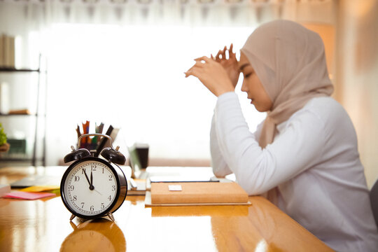 Background Of Impatient Muslim Woman Waiting To Finish Work, Feeling Tired And Displeased. Serious Upset Person Looking At Watch To See Deadline Working Delay. Hard Working Last Night. Close Up Clock