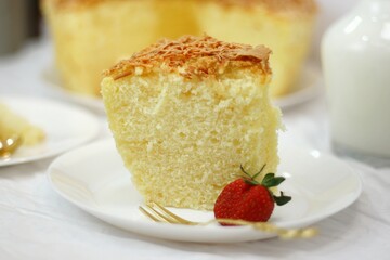 Slice of delicious cheese spongecake isolated on white.
