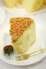 Slice of delicious cheese spongecake isolated on white.