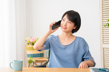 車椅子に座りながら電話をする若い女性　多様性社会イメージ	