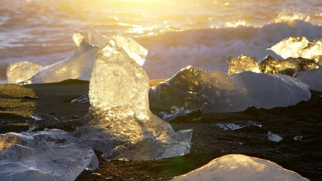 Diamond Beach in Iceland. Icebergs Shining on Black Volcanic Sand at Sunset. Clear Ice Crashed by Ocean Waves. Famous Tourist Location in North Europe Country. Shot in 8K Resolution 4320p
