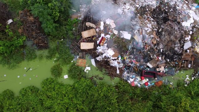 Aerial sliding look down open burning rubbish garbage dump