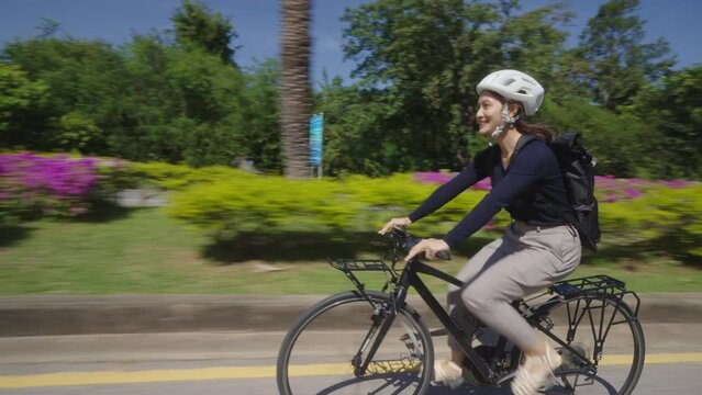 Asian woman bikes to work In good weather
