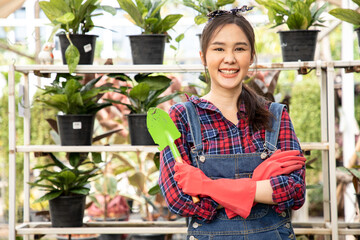 Gardener farmer standing in ornamental plants shop with cross arm. Happy woman owner in her small business shop. Your welcome to my small business