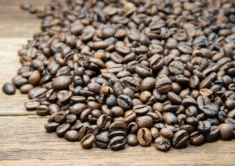 Roasted coffee beans arranged on a wooden floor. Selective focus.