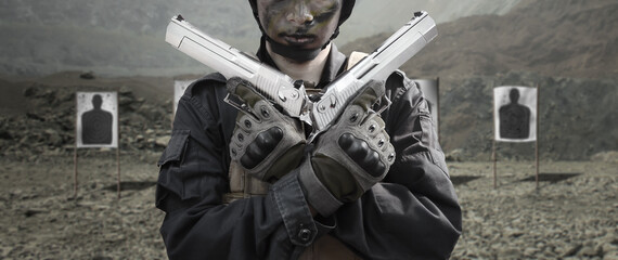 Military soldier shooter holding double pistol handgun dessert eagle  weapon at outdoor academy...