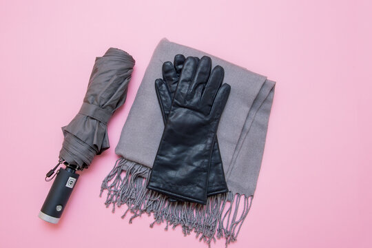 autumn accessories umbrella, gloves and tippet on pink background