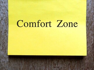 Yellow note on copy space gray wall with text handwritten COMFORT ZONE , concept of psychological state to feel at ease and in control, low anxiety and stress, feel safety