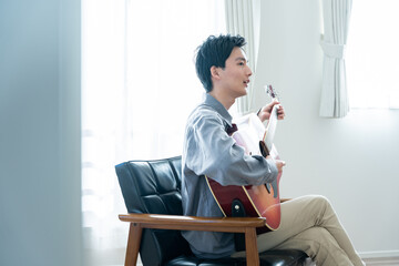 アコースティックギターを弾く若い男性
