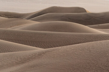 Waves of brown sand hills with ripples