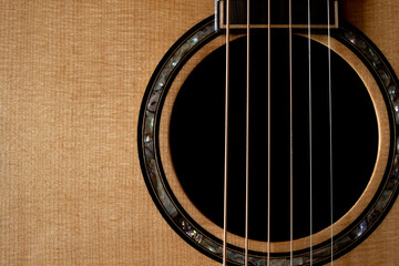 Obraz premium Classic Acoustic guitar close up, dramatically lit on a black background with copy space